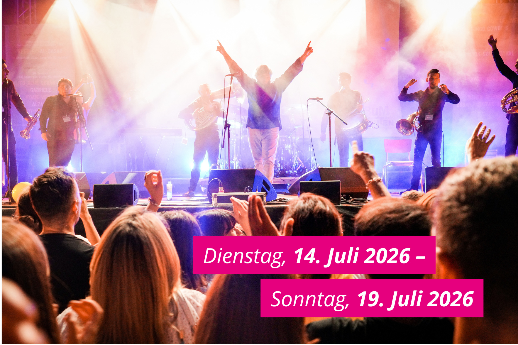 Das Bild zeigt die Bühne des Sommerfestivals der Kulturen. Auf dem Bild ist ein pinkfarbener Balken, der das Datum des kommenden Festivals zeigt: Dienstag, 14. bis Sonntag, 19. Juli 2026