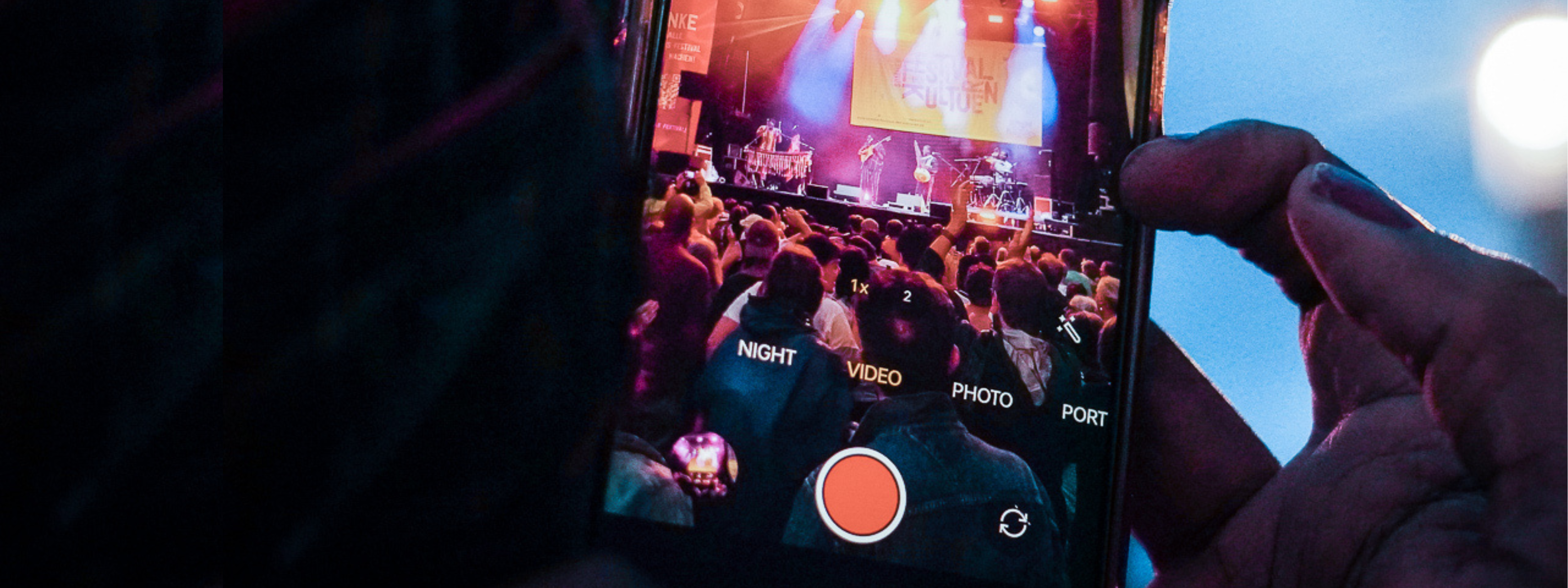 Das Bild zeigt ein Smartphone, das gerade eine Bühnenszene beim Sommerfestival der Kulturen filmt.